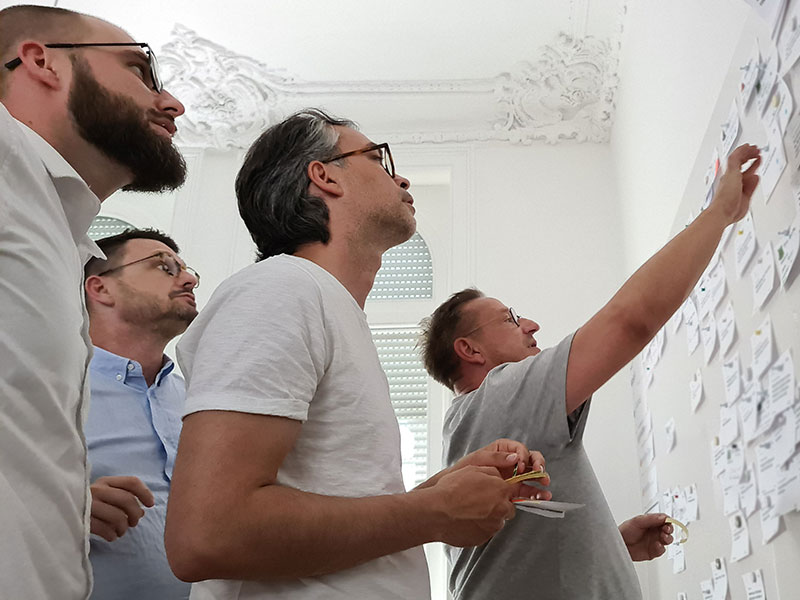 Menschen vor einer Workshop Pinnwand