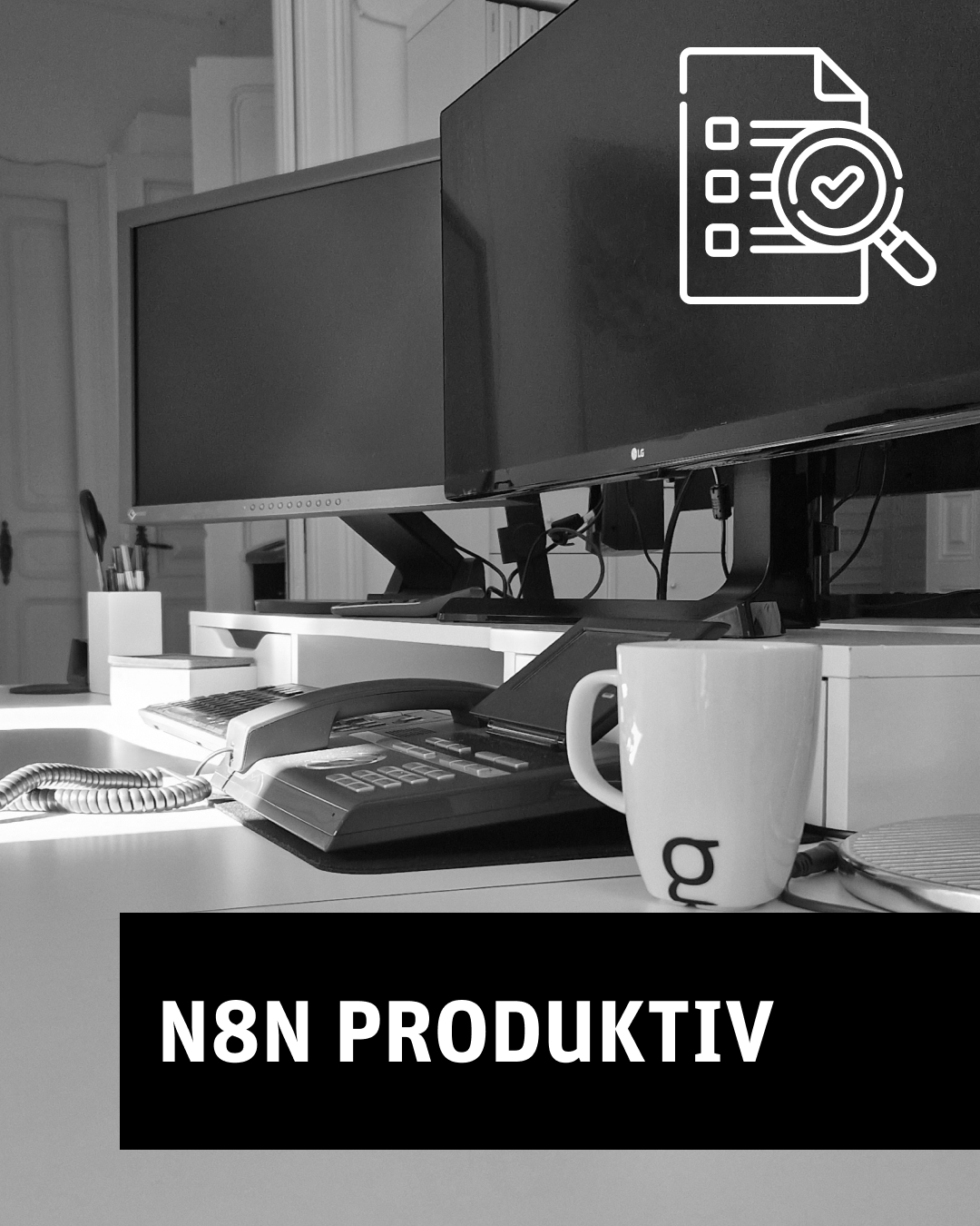 Schwarzweiß-Foto eines Schreibtischs mit Monitoren und der Aufschrift „N8N PRODUKTIV“