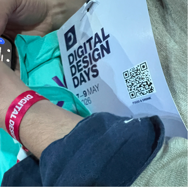 Ticket/Badge der Digital Design Days mit QR‑Code und rotem Armband am Handgelenk