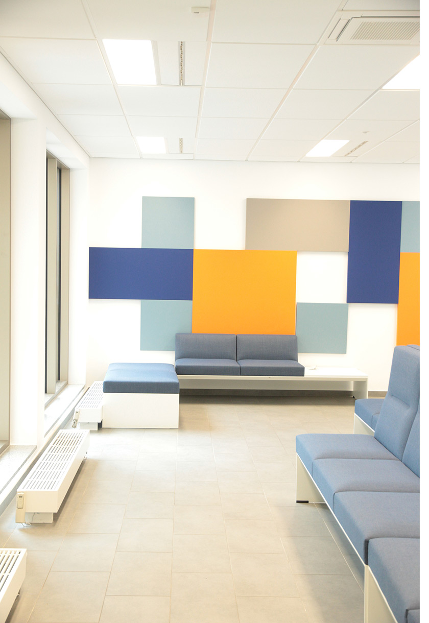 Wartebereich mit blauen Sofas und farbigen Wandpaneelen