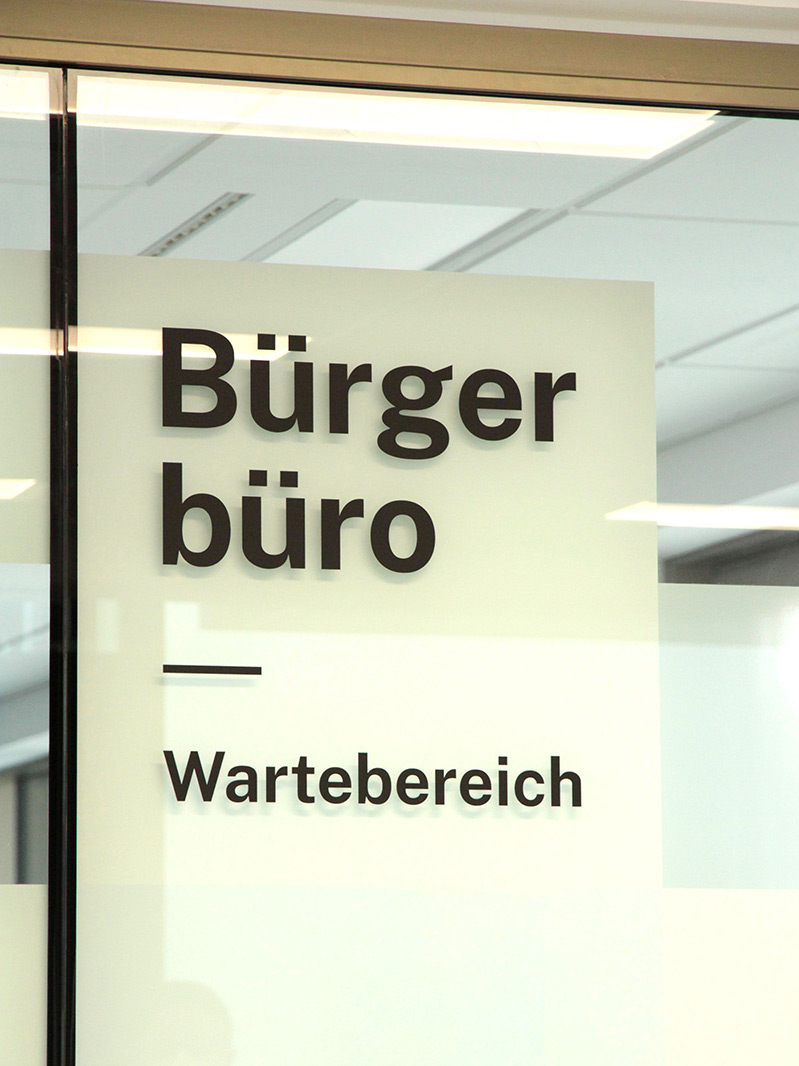Beschriftete Glaswand mit der Aufschrift Bürgerbüro und Wartebereich