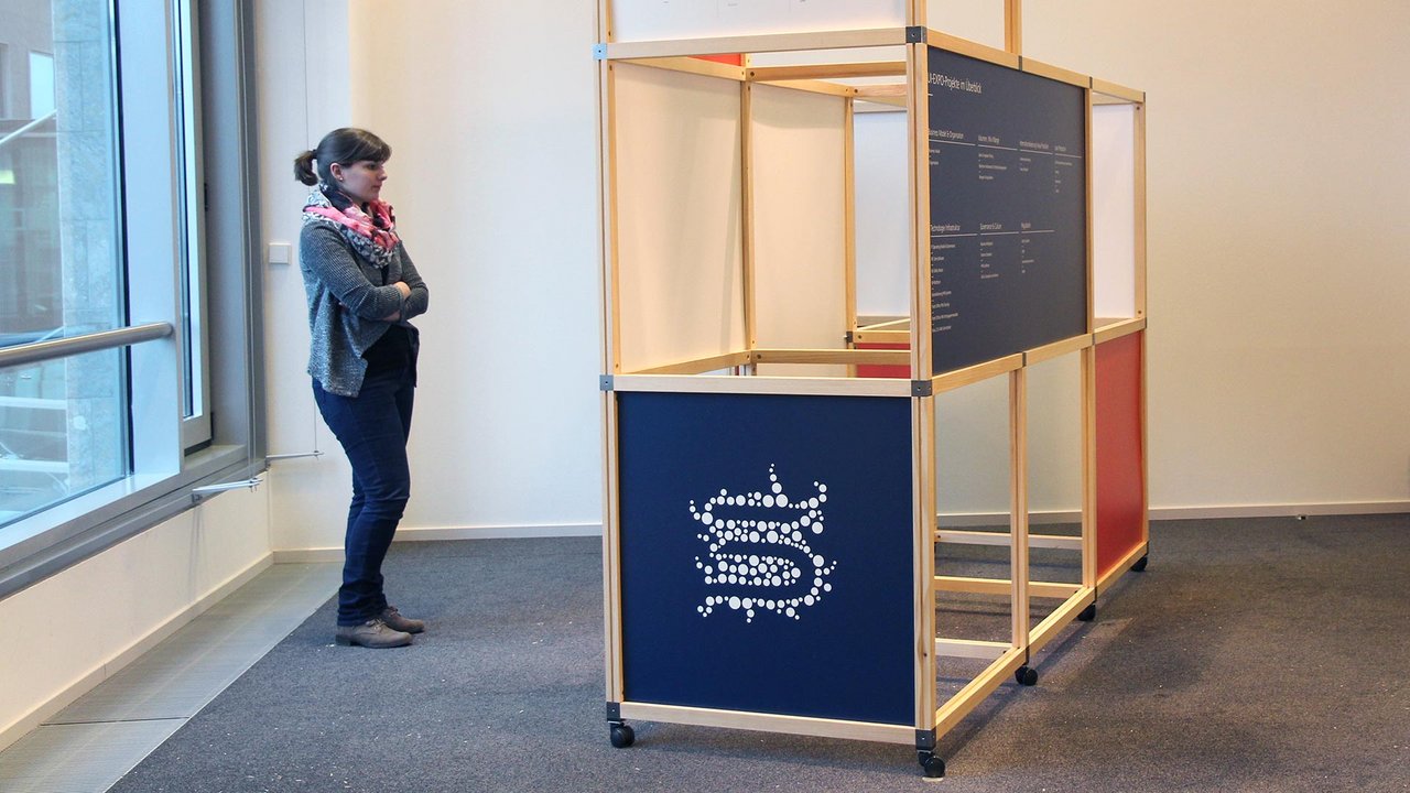 Modulares Ausstellungssystem aus Holzrahmen mit bedruckten Paneelen in Blau, Weiß und Rot