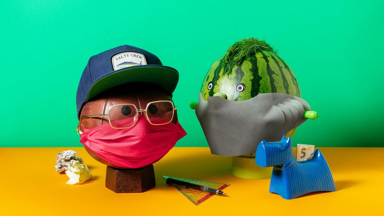 Teaserbild mit zwei Maskenfiguren auf gruenem und gelbem Hintergrund